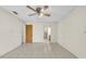 Bright bedroom featuring tile flooring, a ceiling fan, and ensuite bathroom access at 6915 N Hubert Ave, Tampa, FL 33614