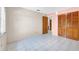 This bedroom features tile floors, wood closet doors, and an open doorway to another room at 6915 N Hubert Ave, Tampa, FL 33614