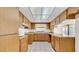 Kitchen with light wood cabinetry, tile backsplash, and a window view to the front yard at 6915 N Hubert Ave, Tampa, FL 33614