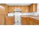 An updated kitchen with light wood cabinets, white appliances, and tile flooring at 6915 N Hubert Ave, Tampa, FL 33614
