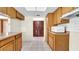 Kitchen with light wood cabinetry, white backsplash tiles and view to the hallway at 6915 N Hubert Ave, Tampa, FL 33614