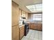 Well-lit kitchen showcases wooden cabinetry, appliances, and a window at 6915 N Hubert Ave, Tampa, FL 33614