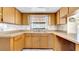 A kitchen with wrap-around counters, light wood cabinets and double sink at 6915 N Hubert Ave, Tampa, FL 33614