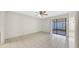 Bright living room featuring tile flooring, ceiling fan, and sliding glass doors at 6915 N Hubert Ave, Tampa, FL 33614