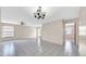 Bright living room with tile floors, neutral walls, ceiling fan, and a chandelier at 6915 N Hubert Ave, Tampa, FL 33614