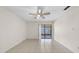 Bright living room featuring tile flooring, a ceiling fan, and sliding glass doors at 6915 N Hubert Ave, Tampa, FL 33614