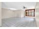 Open-concept living area with tile flooring, chandelier and natural light from large windows at 6915 N Hubert Ave, Tampa, FL 33614