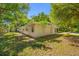 The exterior back view of this home features a fenced yard and mature trees at 810 W River Dr, Temple Terrace, FL 33617