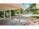 Covered carport with concrete slab and view of home's exterior and front yard at 810 W River Dr, Temple Terrace, FL 33617
