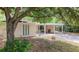 Side view of home with carport featuring a stone accent wall, and xeriscaped front yard at 810 W River Dr, Temple Terrace, FL 33617