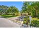 Inviting single-story home with lush landscaping and a concrete driveway leading to a covered carport at 810 W River Dr, Temple Terrace, FL 33617