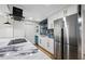 Modern kitchen featuring a stainless steel refrigerator and a marble countertop island at 810 W River Dr, Temple Terrace, FL 33617