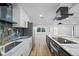 Modern kitchen boasts stainless steel appliances, marble countertops, and sleek white and navy cabinetry at 810 W River Dr, Temple Terrace, FL 33617