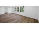 Bright living room with three large windows, wood-look flooring and white trim, offering natural light at 810 W River Dr, Temple Terrace, FL 33617