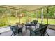 Cozy screened porch furnished with wicker seating and serene backyard views at 8270 Oakgren Rd, Brooksville, FL 34601