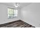 Inviting bedroom featuring wood floors, a ceiling fan, and a large window at 9602 Lake Chase Island Way # 9602, Tampa, FL 33626