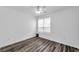 Empty bedroom with wood-look flooring, neutral walls, and a bright window at 9602 Lake Chase Island Way # 9602, Tampa, FL 33626