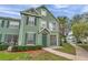 Two-story home with green exterior, shutters, and a well-manicured lawn at 9602 Lake Chase Island Way # 9602, Tampa, FL 33626