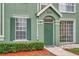 Townhouse front entrance with a green door and neatly trimmed green bushes at 9602 Lake Chase Island Way # 9602, Tampa, FL 33626