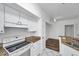 Bright kitchen with white cabinets, stone countertops and floors leading into a spacious living area at 9602 Lake Chase Island Way # 9602, Tampa, FL 33626