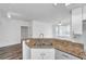 Kitchen features granite countertops with a stainless steel sink overlooking the spacious living area and ceiling fan at 9602 Lake Chase Island Way # 9602, Tampa, FL 33626