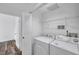 A well-lit laundry room with a modern washer and dryer set and shelf at 9602 Lake Chase Island Way # 9602, Tampa, FL 33626