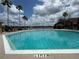 Large community pool with ample seating and lush palm trees creates a resort atmosphere at 9602 Lake Chase Island Way # 9602, Tampa, FL 33626