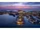 Breathtaking aerial view of a waterfront community at twilight, showcasing beautiful homes and stunning bay views at 100 Sands Point Dr, Tierra Verde, FL 33715