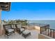 Balcony features two outdoor chairs, an ottoman, and a black metal railing overlooking the water and the city at 100 Sands Point Dr, Tierra Verde, FL 33715