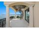 Balcony with columns, spiral staircase, and doors to indoor space overlooks the water at 100 Sands Point Dr, Tierra Verde, FL 33715
