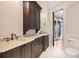 Bathroom featuring dual sinks, dark wood cabinets, and access to outdoor spiral staircase at 100 Sands Point Dr, Tierra Verde, FL 33715