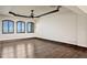 Spacious bedroom featuring hardwood floors, ceiling fan, and three windows with shutters at 100 Sands Point Dr, Tierra Verde, FL 33715
