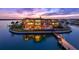 Magnificent waterfront home with outdoor pool, private dock, and beautifully landscaped grounds at sunset at 100 Sands Point Dr, Tierra Verde, FL 33715
