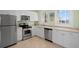 Bright kitchen with stainless appliances, granite countertops, white cabinets, and natural light at 100 Sands Point Dr, Tierra Verde, FL 33715