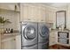 Laundry room with full size washer and dryer and white cabinets and countertop at 100 Sands Point Dr, Tierra Verde, FL 33715