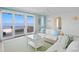 Coastal living room with water views, white furniture, and access to balcony at 100 Sands Point Dr, Tierra Verde, FL 33715