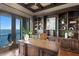 Home office with built-in bookshelves, dark trim, tile floors, and a water view at 100 Sands Point Dr, Tierra Verde, FL 33715
