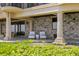 Inviting covered patio with stone accents, comfortable seating, and picturesque views of the pool at 100 Sands Point Dr, Tierra Verde, FL 33715