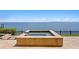 An elevated and modern water-feature pool design overlooks a large ocean inlet with a serene horizon line at 100 Sands Point Dr, Tierra Verde, FL 33715