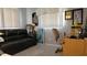 Office with a black leather couch, desk, chair, and window at 10040 38Th N Way, Pinellas Park, FL 33782