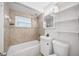 Cozy bathroom featuring a shower-tub combination with tile surround and a vanity with decorative lighting at 10208 N 23Rd St, Tampa, FL 33612