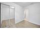 Well-lit bedroom with neutral walls, wood-look flooring, and mirrored closet doors at 10208 N 23Rd St, Tampa, FL 33612