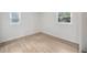 Bright bedroom featuring wood laminate flooring and ample natural lighting from the windows at 10208 N 23Rd St, Tampa, FL 33612