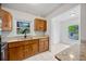 Kitchen boasts wood cabinetry, granite countertops, and white tile flooring with view into breakfast nook at 10208 N 23Rd St, Tampa, FL 33612