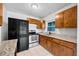 Bright kitchen featuring stainless steel appliances, wood cabinets, and granite countertops at 10208 N 23Rd St, Tampa, FL 33612
