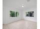 Living room featuring tiled floors and two large picture windows at 10208 N 23Rd St, Tampa, FL 33612