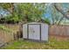 Exterior view of the metal storage shed in backyard with wooden fencing and foliage at 10208 N 23Rd St, Tampa, FL 33612