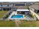Aerial view of backyard featuring pool with sun shelf, screened patio, outdoor kitchen, and solar panels at 10313 Wine Press Ave, Riverview, FL 33578