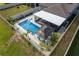 Aerial view of the pool and patio area, featuring an outdoor seating area and shade at 10313 Wine Press Ave, Riverview, FL 33578
