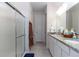 Bright bathroom features a double vanity with granite countertop and glass enclosed shower at 10313 Wine Press Ave, Riverview, FL 33578